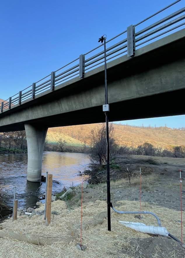 Hyperspectral sensor installed at Walker Bridge on the Klamath River, with solar panel and mounting pole beside the river