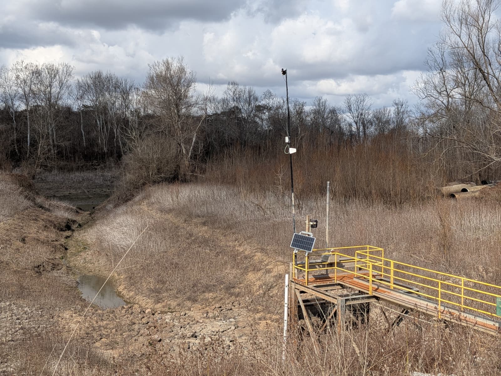 Aqualytics sensor platform with solar panel mounted over the dry intake ditch at Loch Leven — the monitoring station in winter conditions